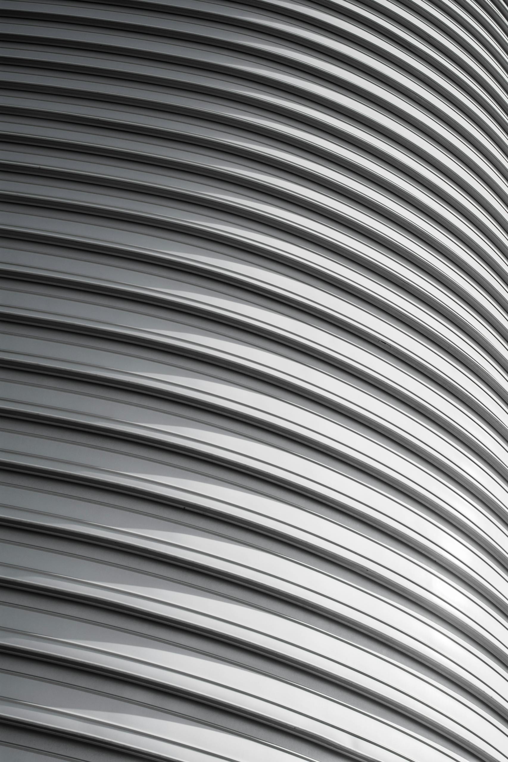Detailed shot of a modern corrugated metal facade highlighting light and shadow patterns.